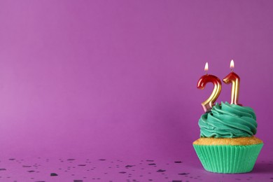 Photo of Delicious cupcake with number shaped candles on purple background, space for text. Coming of age party - 21th birthday