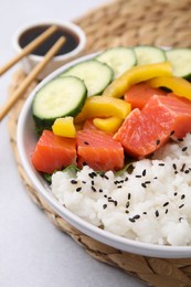 Delicious poke bowl with salmon, rice and vegetables on white table, closeup
