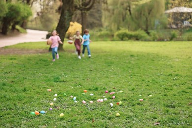 Photo of Easter celebration. Little children hunting eggs outdoors, selective focus