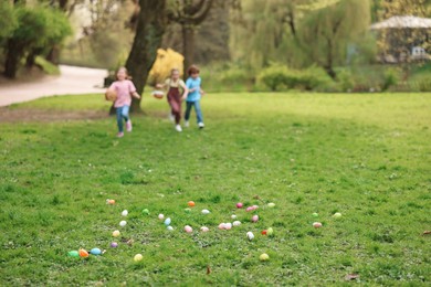 Easter celebration. Little children hunting eggs outdoors, selective focus