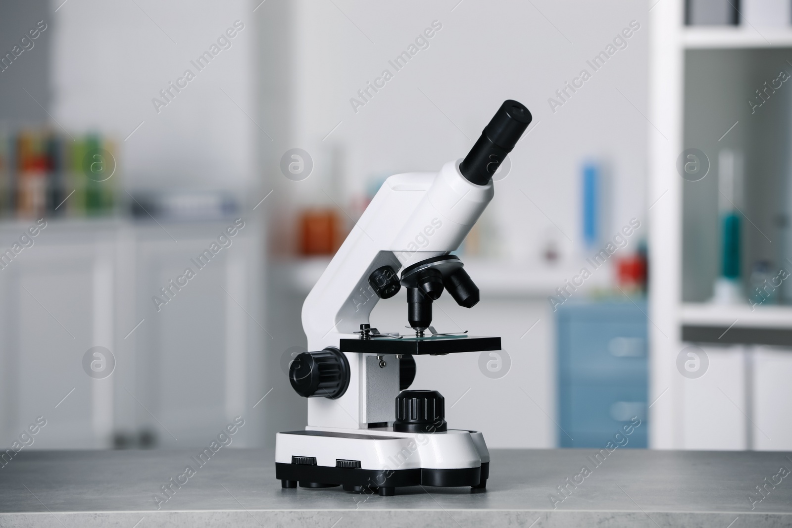 Photo of Modern medical microscope on grey table in laboratory