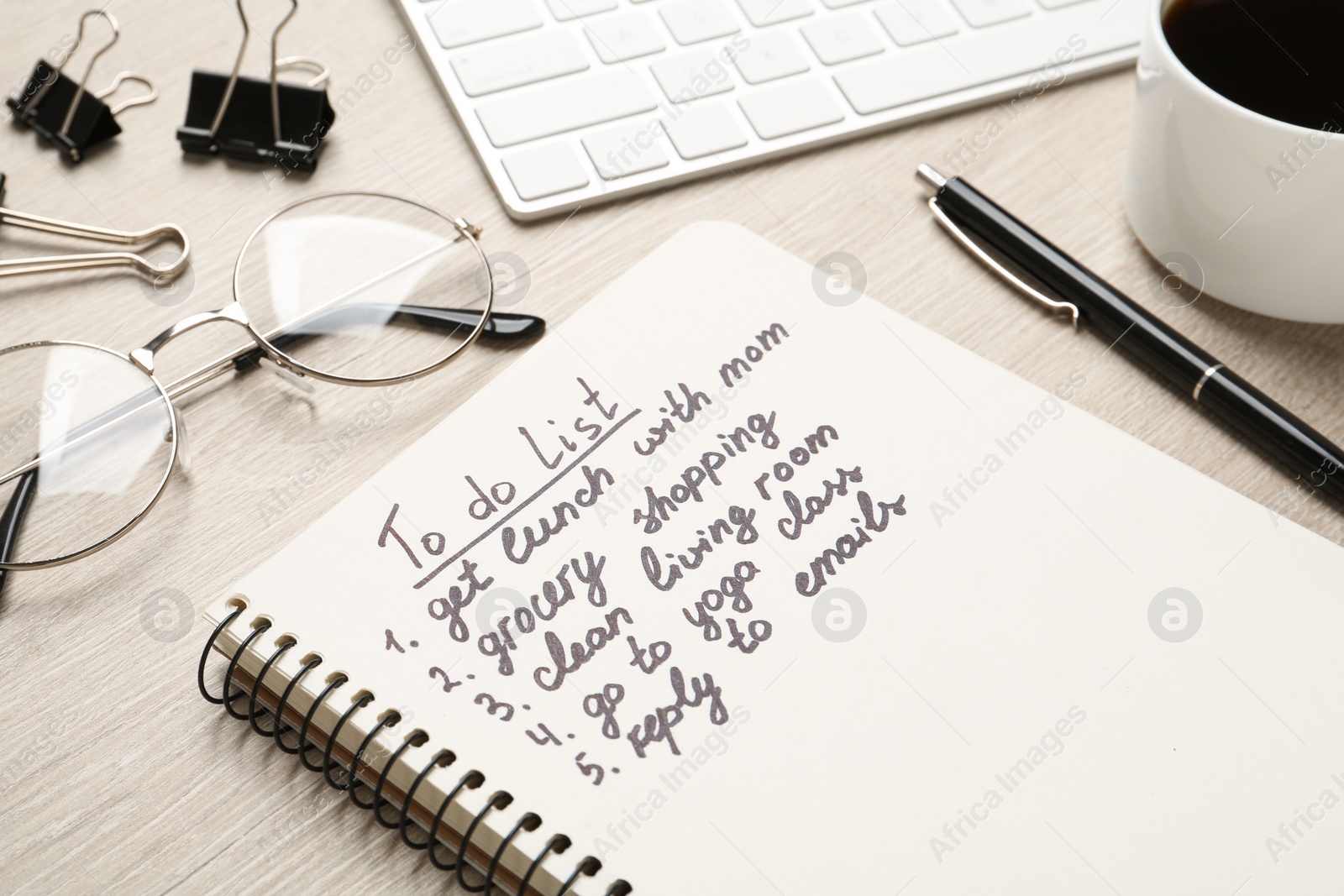 Photo of Notebook with to do list on wooden table