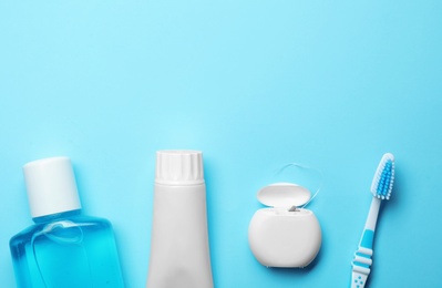 Photo of Flat lay composition with toothpaste, oral hygiene products and space for text on color background