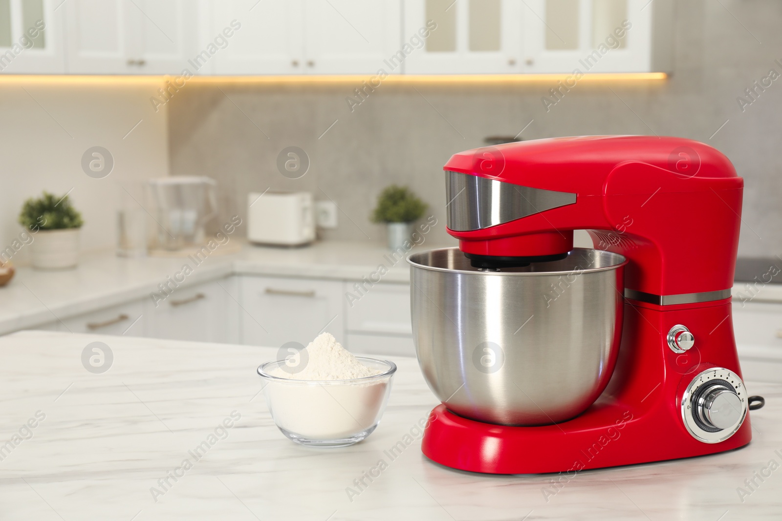 Photo of Modern red stand mixer and bowl with flour on white marble table in kitchen, space for text