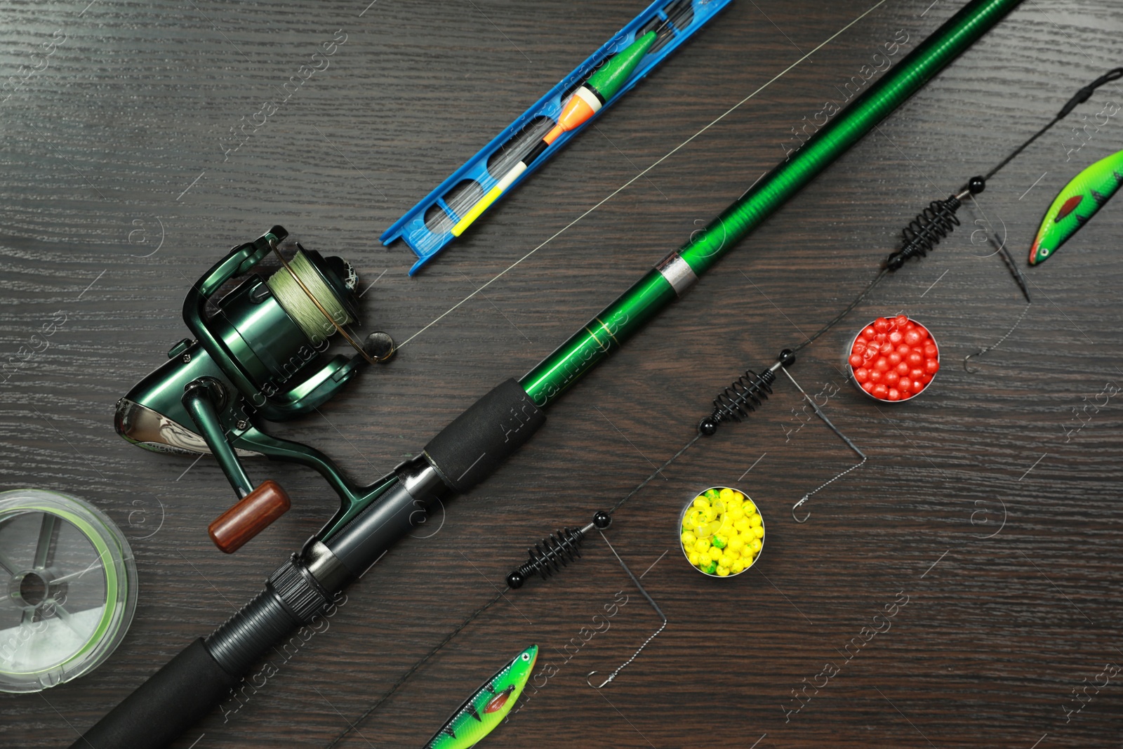 Photo of Fishing tackle on dark wooden background, flat lay