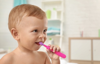 Photo of Cute little boy with toothbrush on blurred background