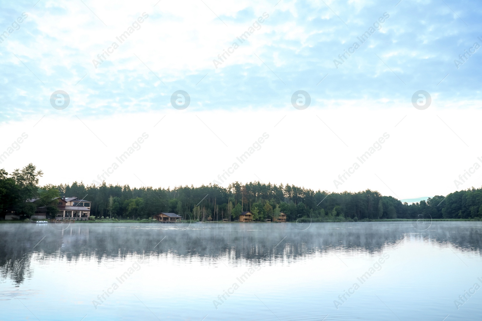 Photo of Beautiful landscape with forest and houses near lake. Camping season