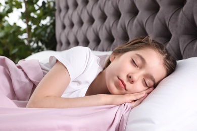 Beautiful little girl sleeping in bed at home