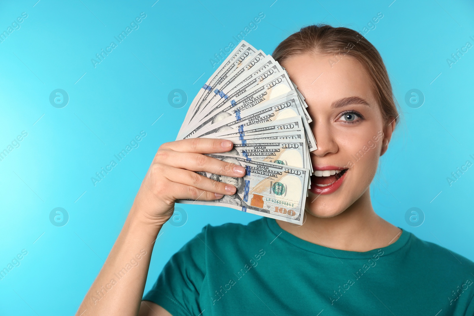 Photo of Portrait of happy young woman with money on color background. Space for text