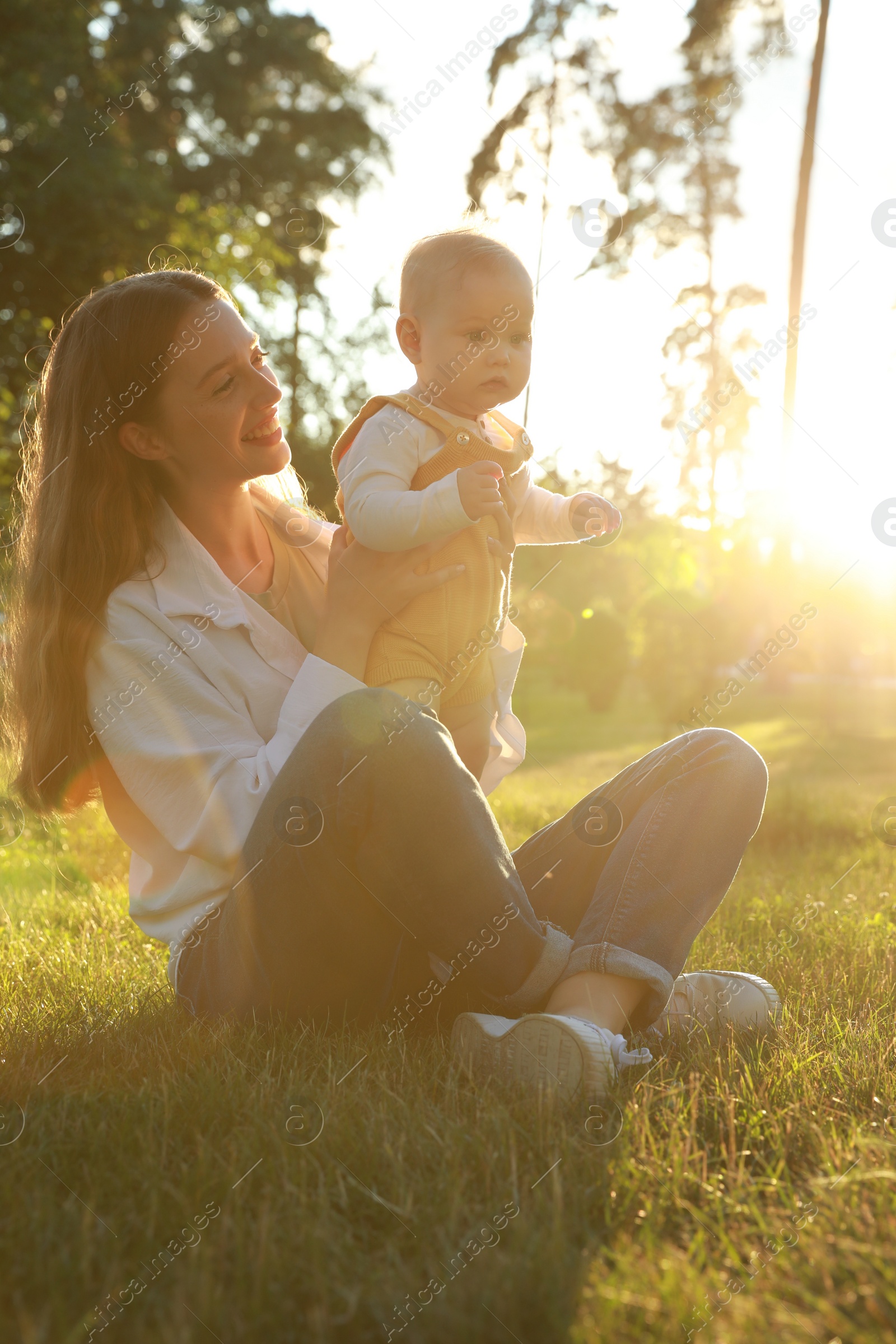 Photo of Beautiful mother with her cute daughter spending time together in park on summer day