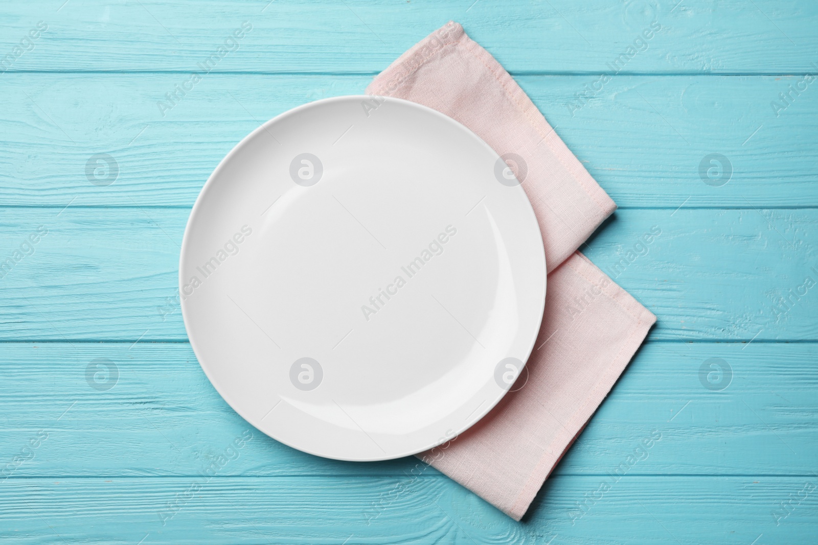 Photo of Stylish ceramic plate and napkin on color wooden background, flat lay