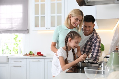 Photo of Happy family cooking together in modern kitchen