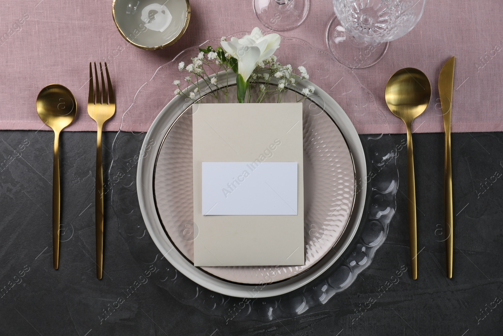 Photo of Stylish table setting. Dishes, cutlery, blank card and floral decor, flat lay