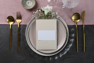 Stylish table setting. Dishes, cutlery, blank card and floral decor, flat lay