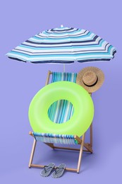 Photo of Deck chair, umbrella and other beach accessories on purple background. Summer vacation