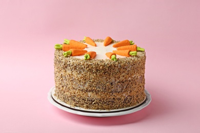 Photo of Dish with tasty carrot cake on pink background