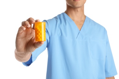 Male doctor holding pill bottle on white background, closeup. Medical object