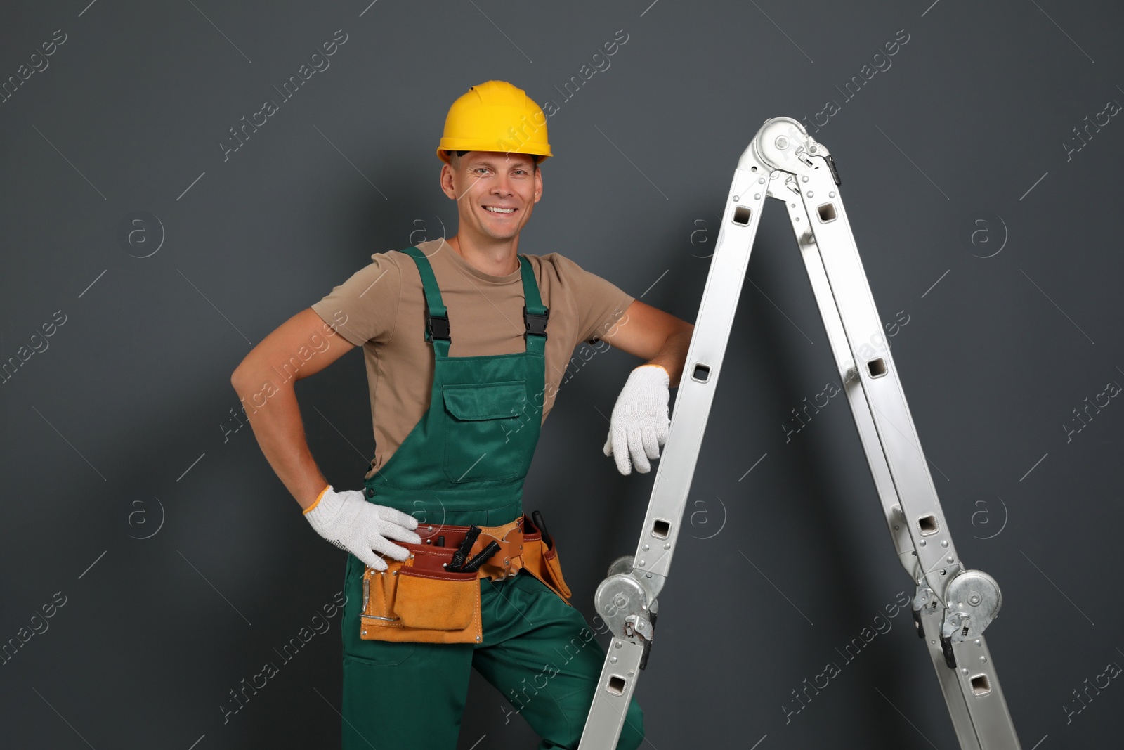 Photo of Professional constructor near ladder on black background