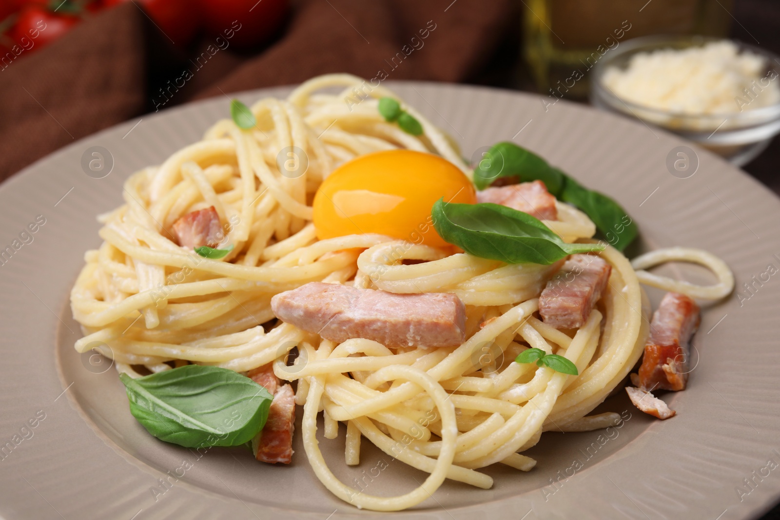 Photo of Delicious pasta Carbonara with egg yolk on plate, closeup