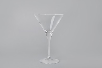 Empty clean martini glass on grey background