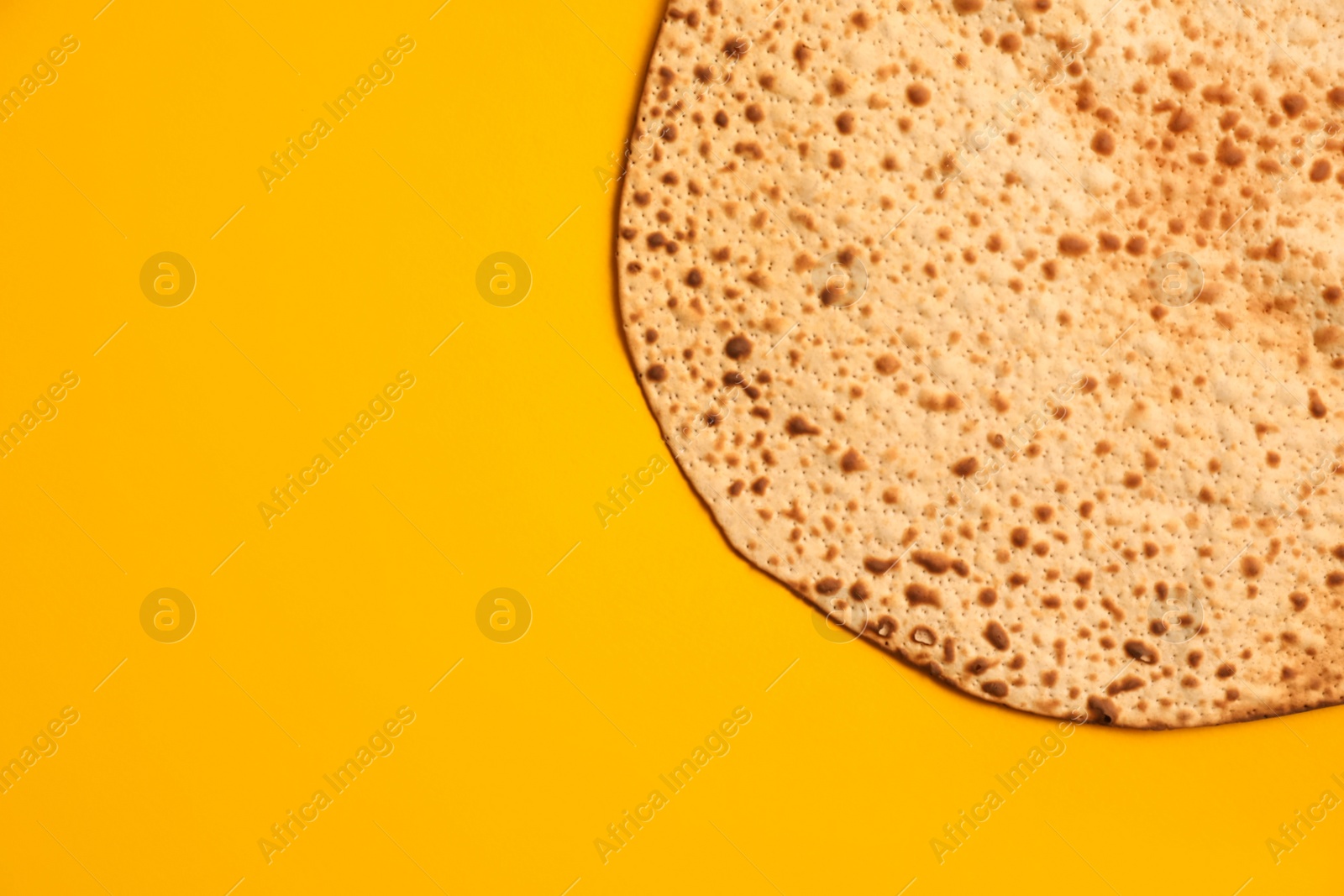 Photo of Tasty matzo on yellow background, top view with space for text. Passover (Pesach) celebration