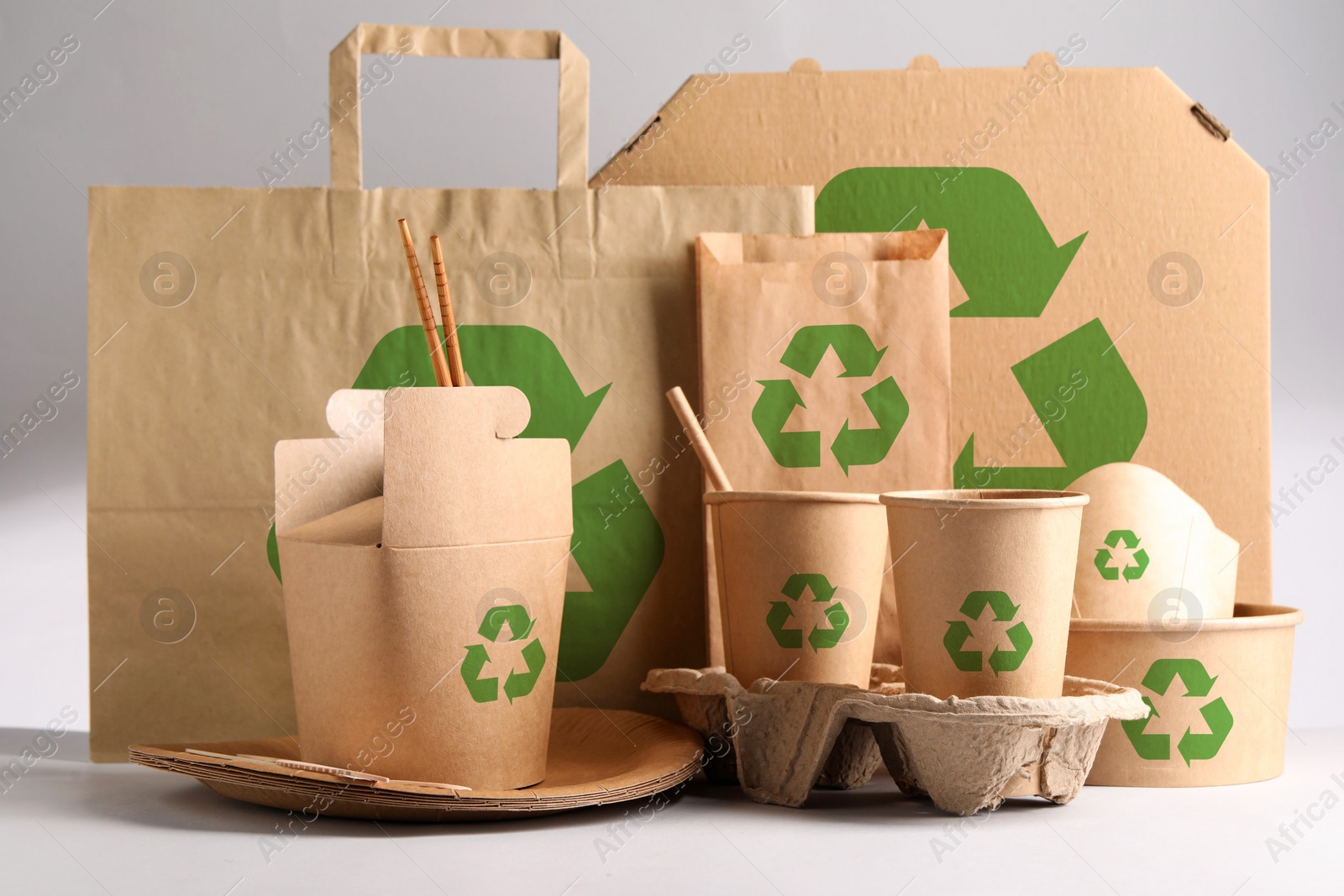 Image of Set of eco friendly food packaging with recycling symbols on light background