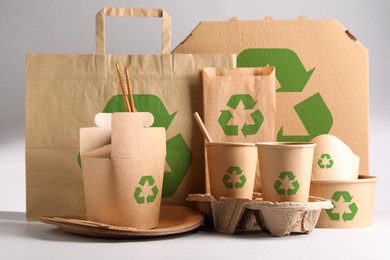 Set of eco friendly food packaging with recycling symbols on light background