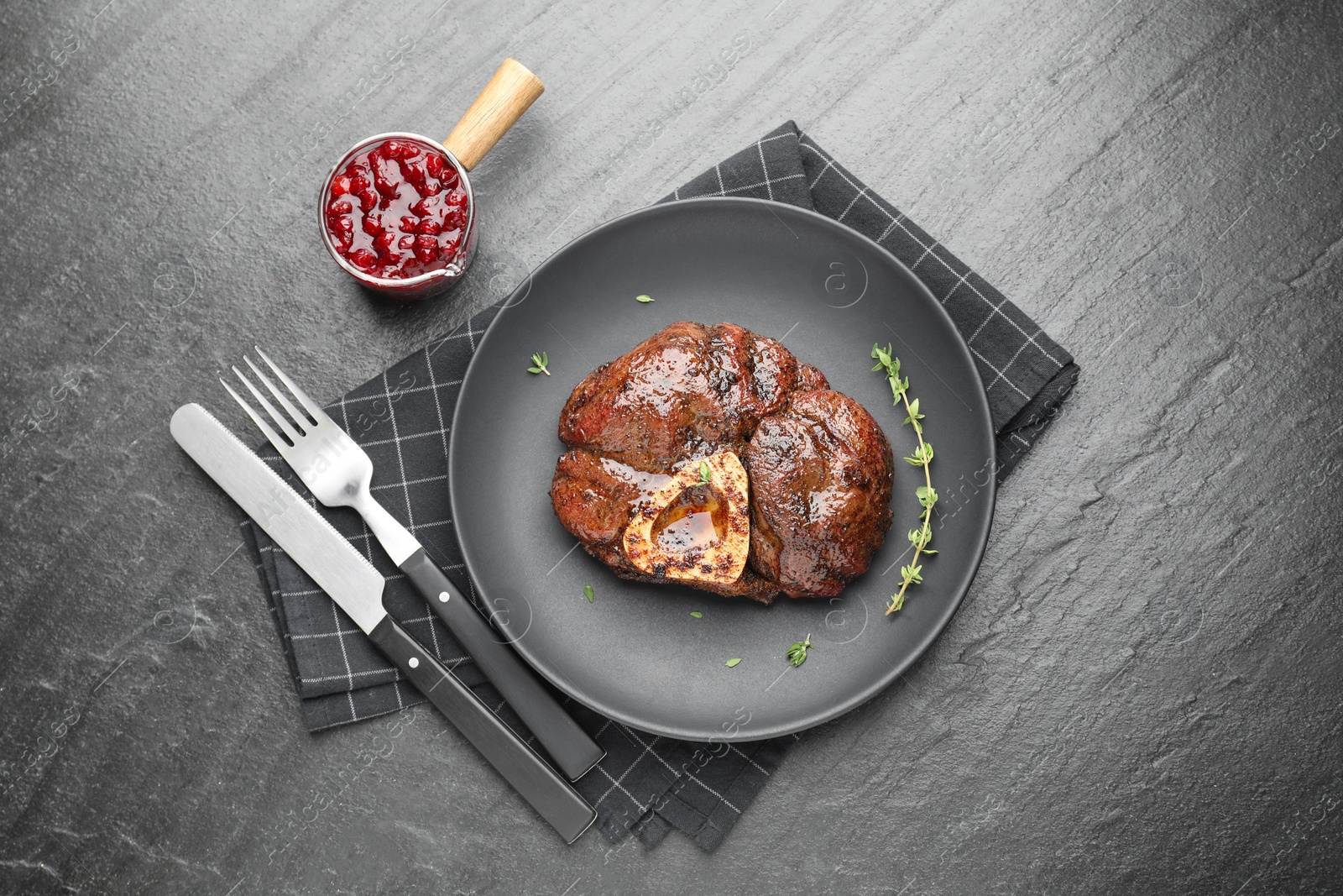 Photo of Delicious roasted beef meat served with sauce on black table, flat lay