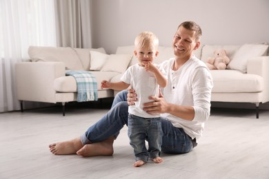 Father with his cute little son in living room