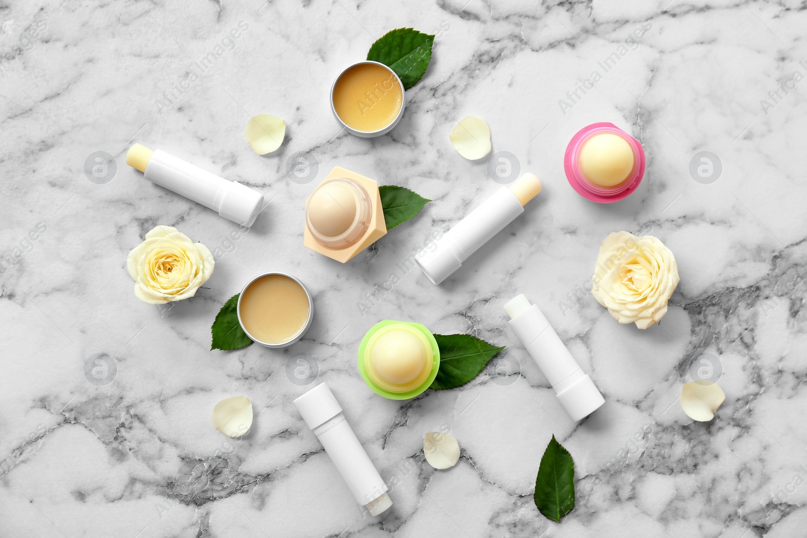 Photo of Flat lay composition with hygienic lipsticks and balms on light background