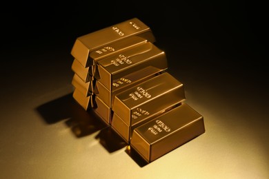 Photo of Stack of shiny gold bars on color background