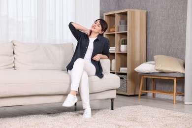 Photo of Beautiful young housewife on sofa at home