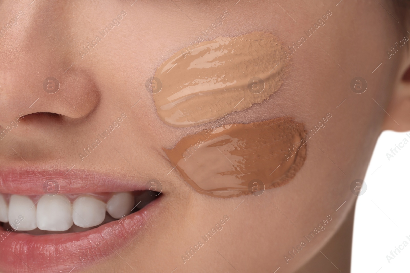 Photo of Teenage girl with swatches of foundation on face against white background, closeup