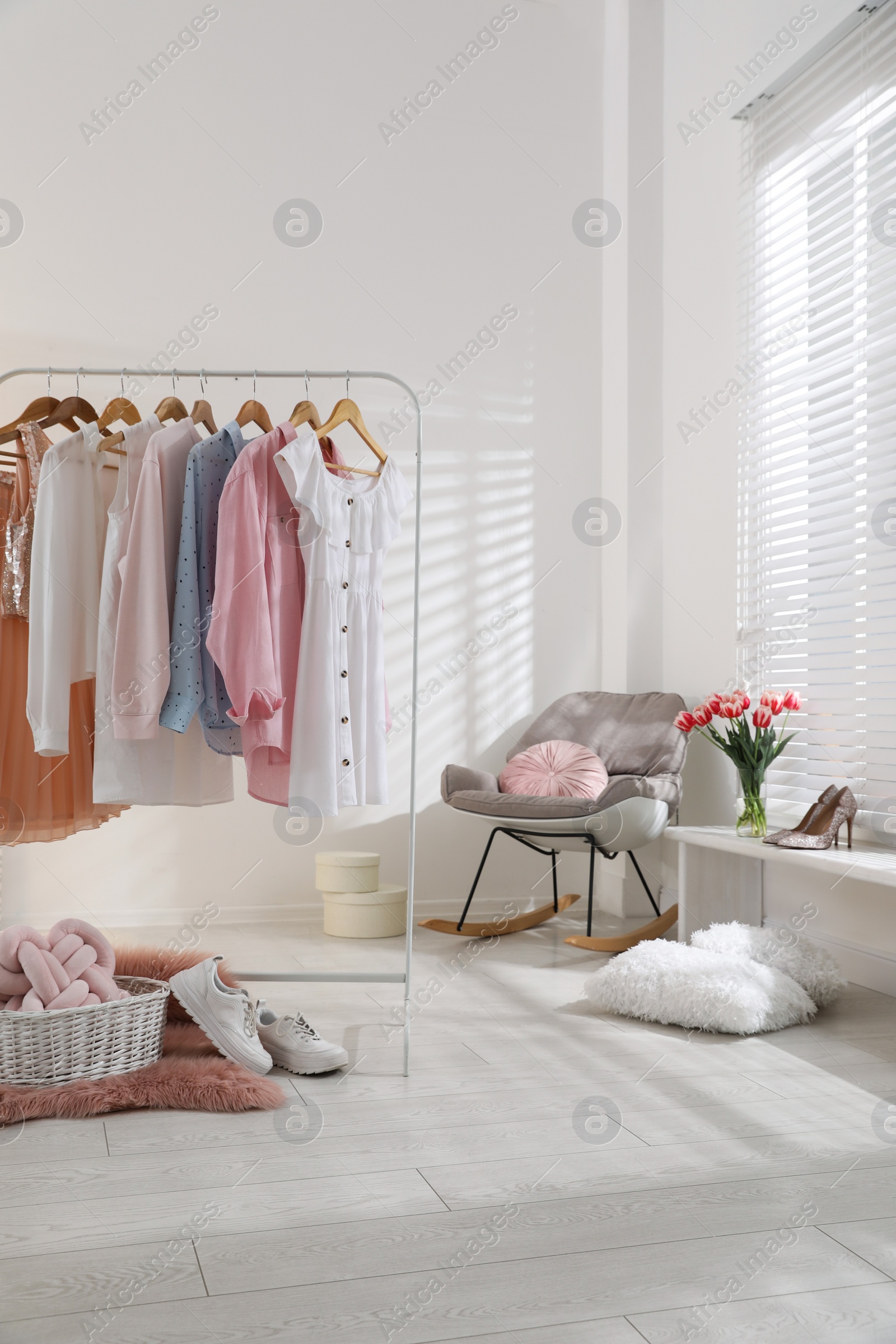 Photo of Rack with stylish women's clothes indoors. Interior design