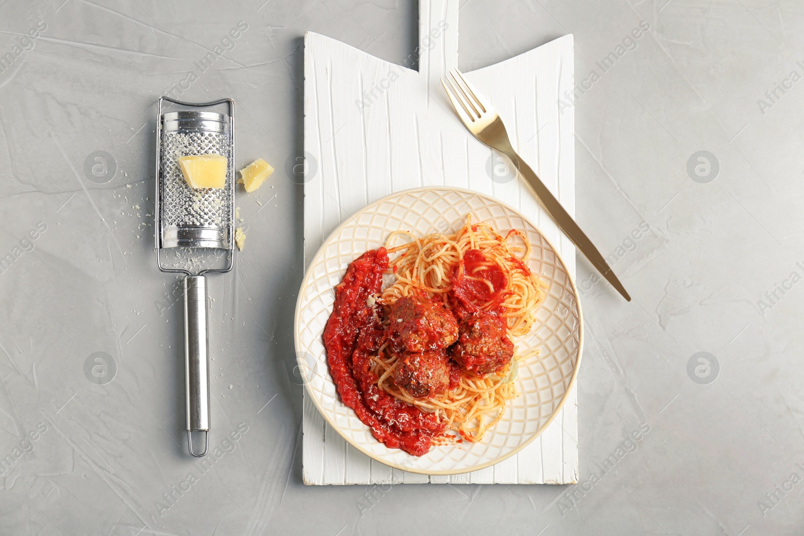 Photo of Delicious pasta with meatballs and tomato sauce on grey background, flat lay