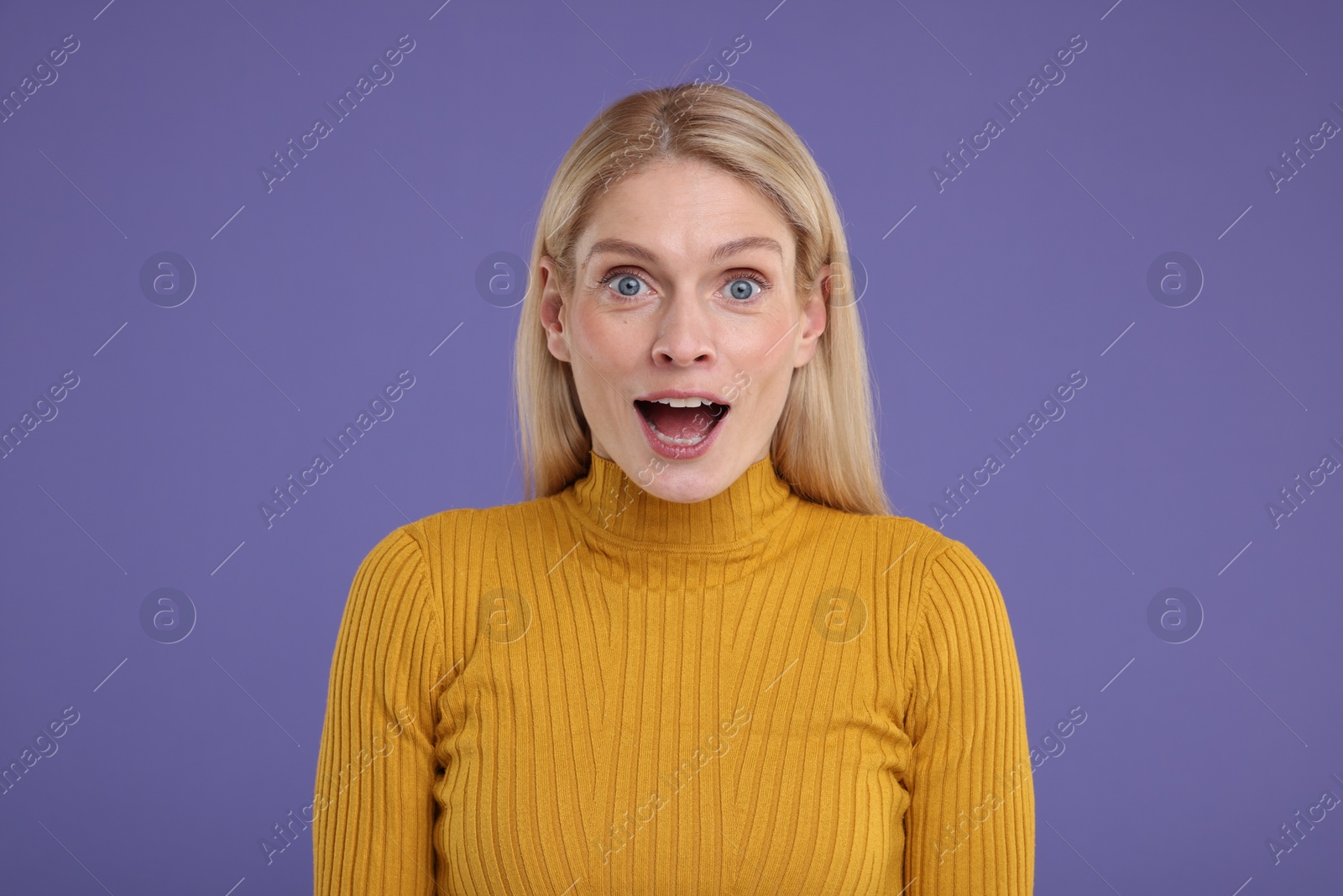 Photo of Portrait of surprised woman on violet background