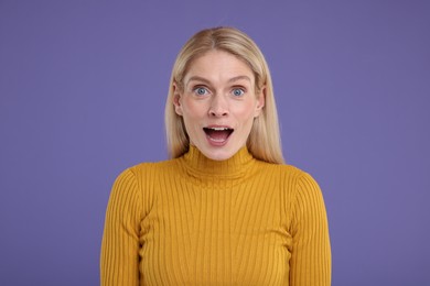 Photo of Portrait of surprised woman on violet background