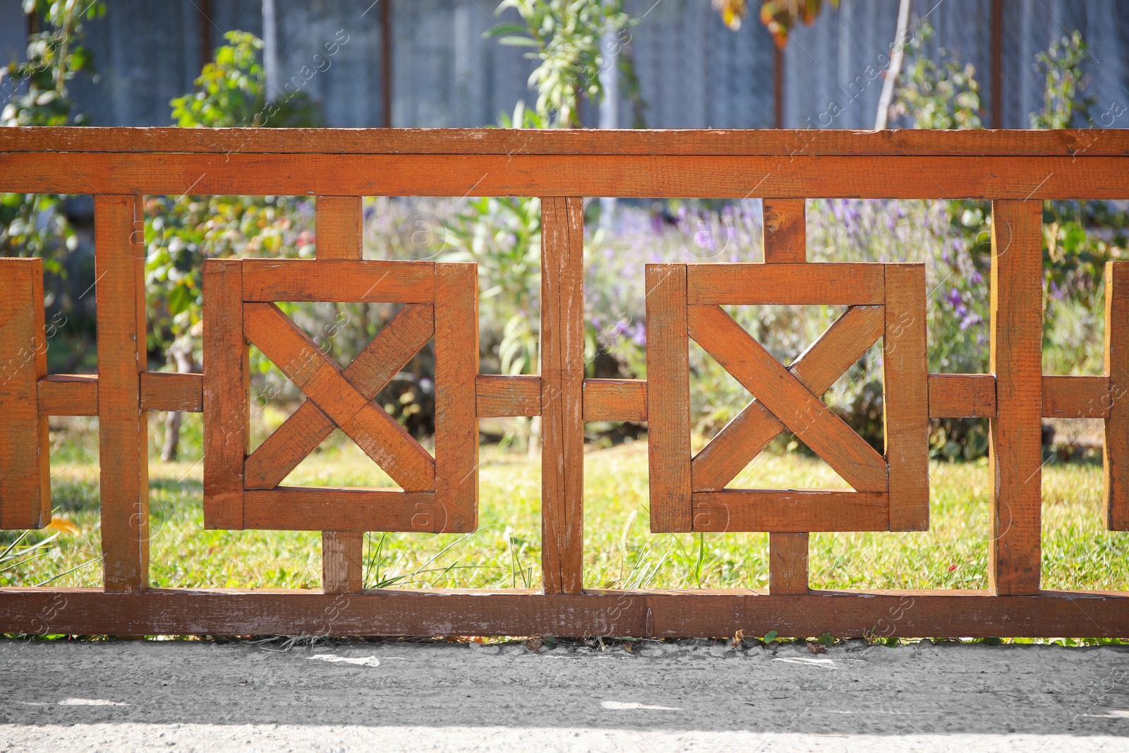 Photo of Beautiful wooden fence near green lawn on sunny day outdoors