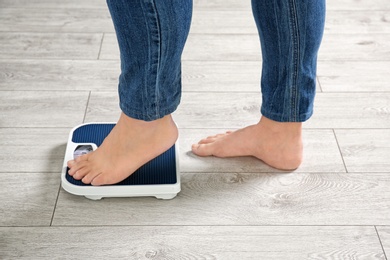 Photo of Overweight woman using scales indoors