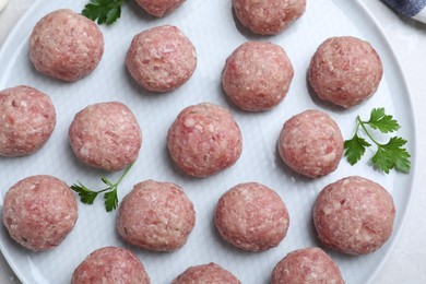 Many fresh raw meatballs on white table, top view