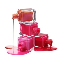 Color nail polishes dripping from bottles isolated on white