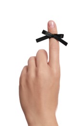 Woman showing index finger with tied black bow as reminder on white background, closeup