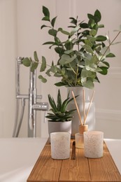 Photo of White bathtub with stylish decor and houseplants in bathroom. Interior design