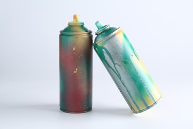 Two spray paint cans on white background