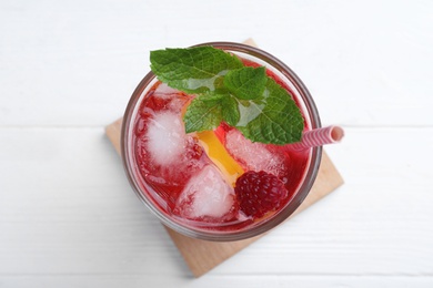 Delicious raspberry lemonade made with soda water on white wooden table, top view