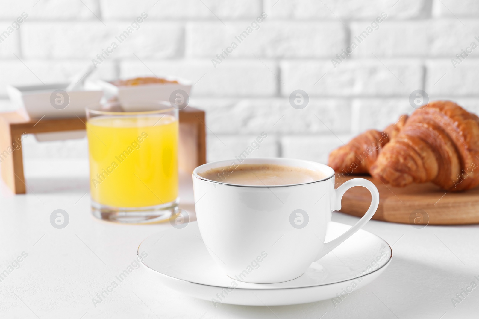 Photo of Fresh croissants and coffee on white table. Tasty breakfast