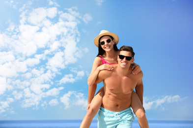 Happy couple having fun on sunny beach. Space for text