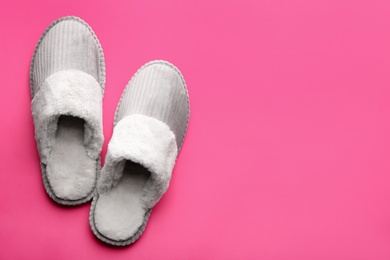 Photo of Pair of soft slippers on pink background, flat lay. Space for text