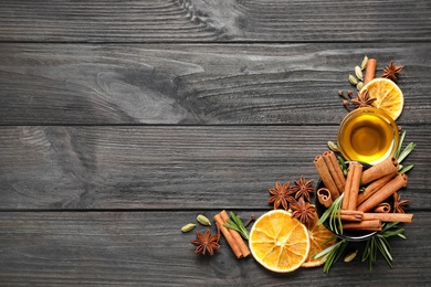 Photo of Flat lay composition with mulled wine ingredients on black wooden table. Space for text