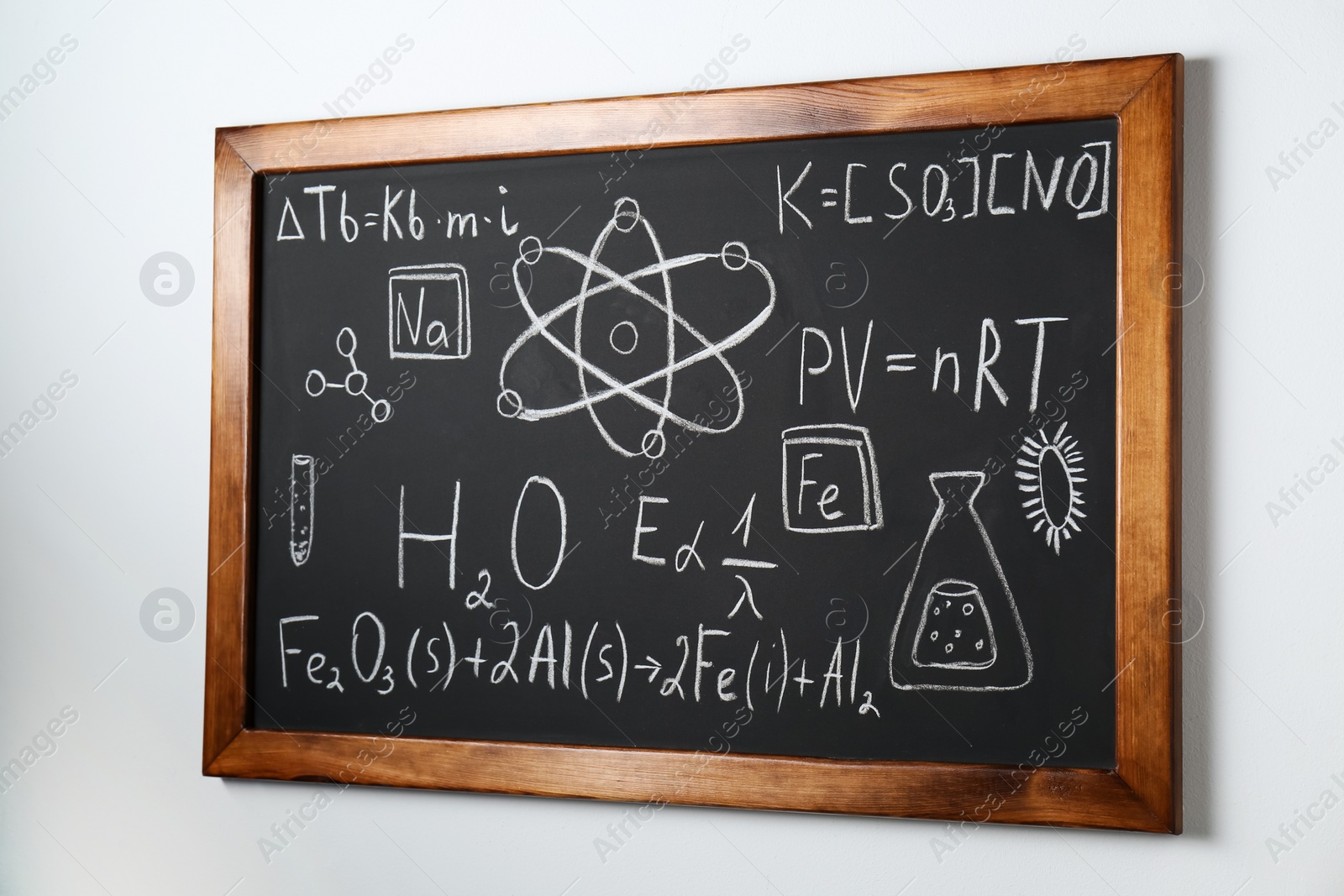 Photo of Blackboard with different chemical formulas written with chalk on white wall